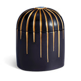 Dark blue cylinder candle posed from side to show gold drip details from eye motif