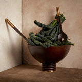 Alhambra hand-carved, fine smoked ash bowl floating on stacked wood pedestal with a brass base. Alhambra serving utensil set.