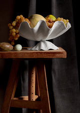 Neptune Bowl - Large. White porcelain shell-shaped bowl floating on a base. 